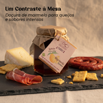 Geleia de marmelo biológica Geocakes apresentada numa tábua com queijo e enchidos